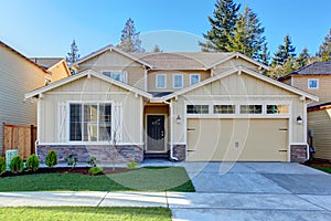 Perfect tan town house with garage and driveway.