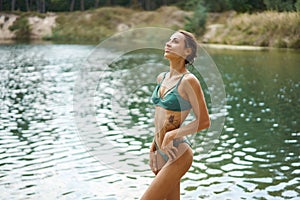 Perfect tanned woman fit body in bikini in nature