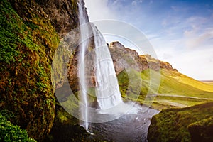 Perfect view of famous powerful Seljalandfoss waterfall in sunlight