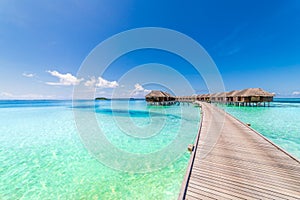 Perfect view of luxury water villas in Maldives island. Blue sea and blue sky, idyllic sea view from a wooden pier pathway