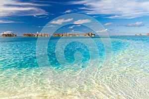 Perfect view of luxury water villas in Maldives island. Blue sea and blue sky, idyllic sea view from a wooden pier pathway