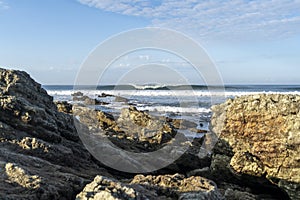 Perfect wave breaking behind the rocks