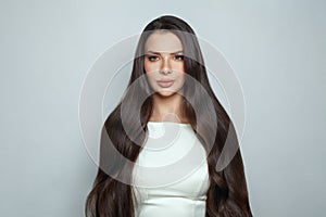 Perfect woman with long smooth straight healthy silky hair on white background. Haircare and beauty concept