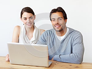 Perfect working companions. Portrait of a handsome man and a beautiful young woman working together on a laptop.