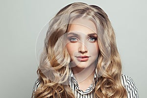 Perfect young woman with long curly blonde hairdo on white