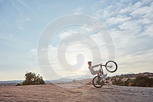 Perfecting the art of biking. a young man out mountain biking during the day.