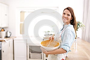 Perfecting her baking skills. A mature woman smiling as she bakes in the kitchen.