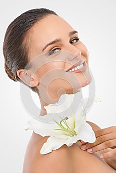 Perfecting perfection. Studio beauty shot of an attractive brunette woman holding a flower.