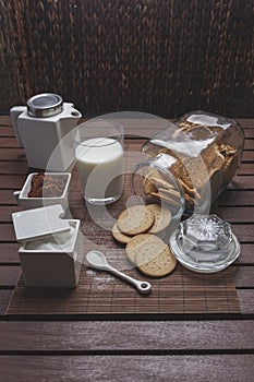 Perfectly crafted coffee table with crunchy cookies, a cup of hot milk and coffee powder