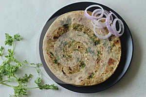 Perfectly round Paratha. Indian flatbread made of wheat flour topped with sesame seeds and coriander leaves