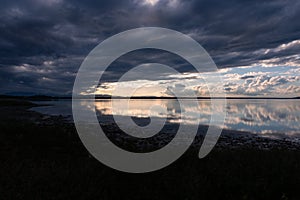 Perfectly symmetric clouds reflections on a lake at golden hour