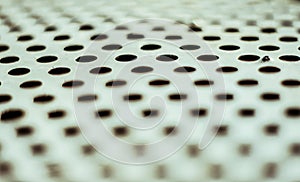 Perforated aluminium sheet of metal texture. Old surface with depth of field, abstract industrial mesh vintage background