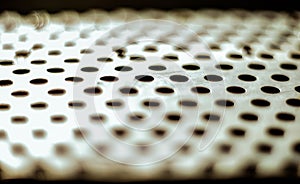 Perforated aluminium sheet of metal texture. Surface with depth of field, abstract industrial mesh background