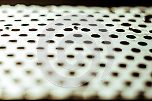 Perforated aluminium sheet of metal texture. Surface with depth of field, abstract industrial mesh grunge background