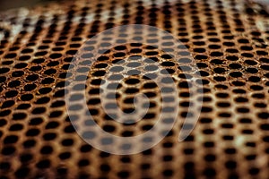 Perforated brown rusty iron sheet texture. Surface with depth of field, abstract mesh. Horizontal grunge background