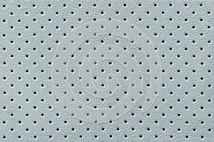 Perforated light blue leather texture background, closeup. backdrop from wrinkle skin