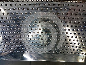 Perforated metal texture close up chrome surface