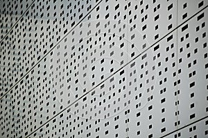 Perforated metal wall background in perspective.