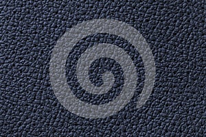 Perforated navy blue leather texture background, closeup. Denim backdrop from wrinkle skin