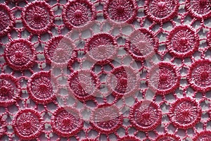 Perforated pink lacy fabric from above