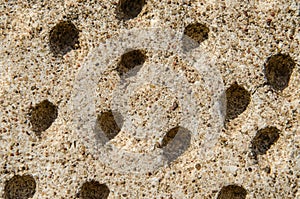 perforations in the concrete wall of the old temple. unusual surface texture with holes. Close-up. Work of the perforator