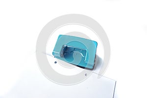 Perforator, blue hole puncher is going to punch the paper isolated on a white