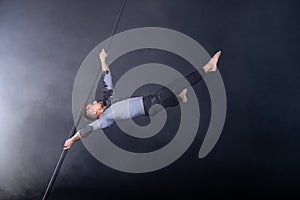 Performance concept. Man hanging on chinese pole. Athlete performing flying pole