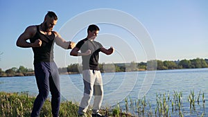 The performance of Wing Chun between master and follower near river. 4k