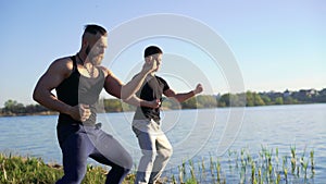 The performance of Wing Chun between strong men near river. 4k