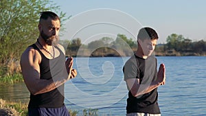 The performance of Wing Chun by strong men near river. Slowly