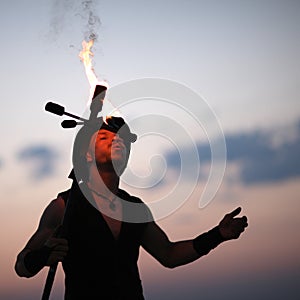 Performer fanning a spark into a fire