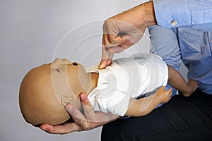 Performing cpr on a simulation mannequin baby dummy during medical training Pediatric Basic Life Support