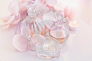 perfume and aromatic oils bottles surrounded by flowers and candles