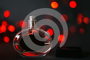 Perfume bottle on a black background with red lights