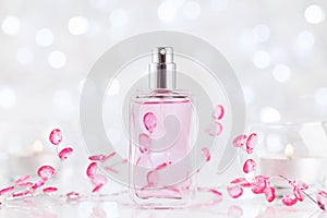 Perfume bottle from glass with fresh fragrance on white table. Beauty and perfumery background.