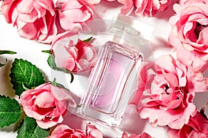 Perfume bottle in pink flower roses. Spring background with luxury aroma parfume. Beauty cosmetic shot