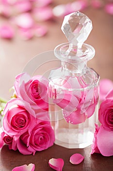 Perfume bottle and pink rose flowers. spa aromatherapy