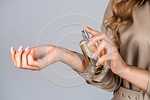 Perfume bottle woman spray aroma. Girl holding a perfume bottle. Womens with perfume bottle. Beautiful girl using