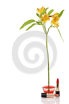 Perfume bottle, yellow flower and two red lipstick