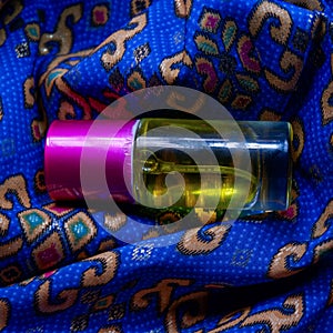 Perfume bottle with a yellow perfume color on a blue batik background