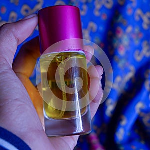 Perfume bottle with a yellow perfume color on a blue batik background