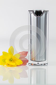 Perfume bottle with yellow and red flowers on white background