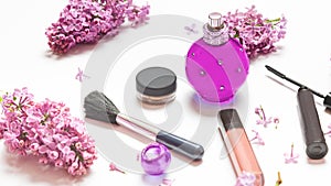 Perfume bottles and decorative cosmetics, lilac flowers on white table background. perfumery and floral scent concept