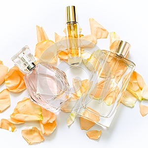 Perfume bottles with flower petals on light background. Perfumery, fragrance collection. Women accessories.