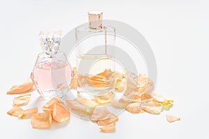 Perfume bottles with flower petals on light background. Perfumery, fragrance collection. Women accessories.