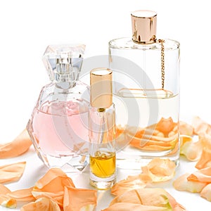 Perfume bottles with flower petals on light background. Perfumery, fragrance collection. Women accessories.