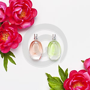 Perfume bottles and pink flowers peonies on light gray background top view Flat lay copy space. Perfumery, cosmetics, female