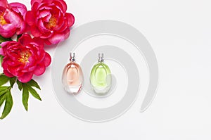 Perfume bottles and pink flowers peonies on light gray background top view Flat lay copy space. Perfumery, cosmetics, female