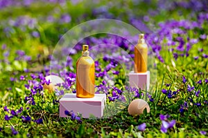 perfume bottles with purple flowers on a meadow in spring time