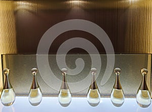 Perfume bottles of toilet water stand on a shelf with illumination